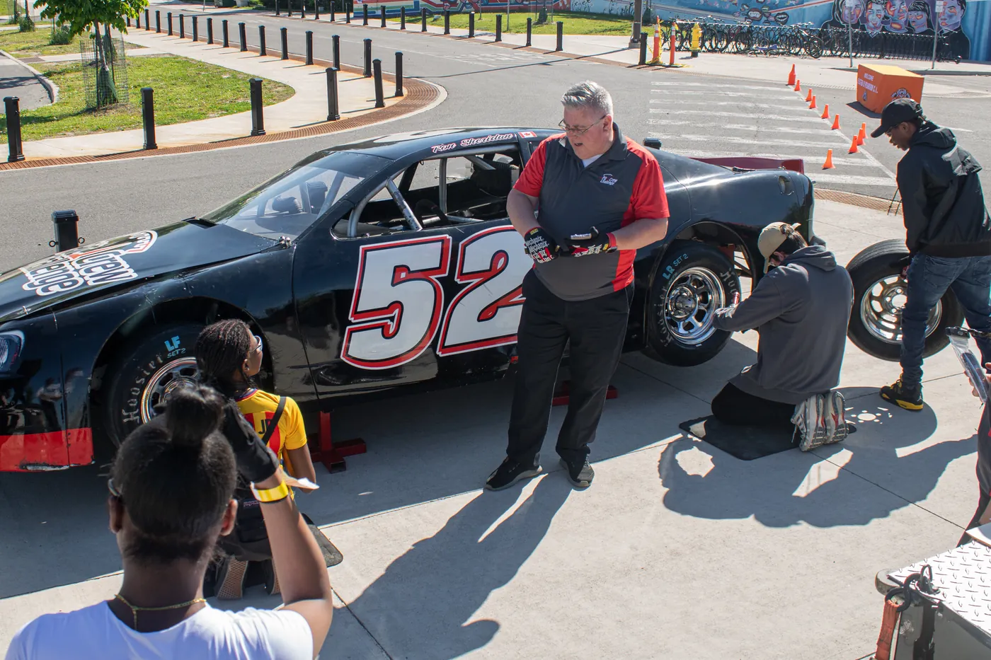 A participant photographing a race car at Drive Forward