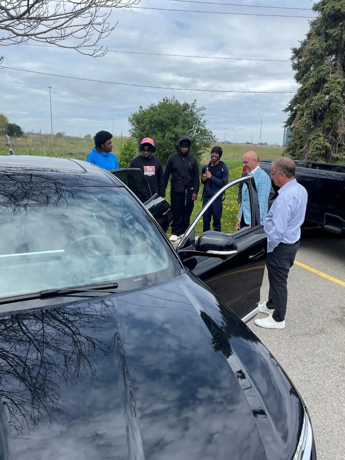 Students looking at a vehicle outdoors