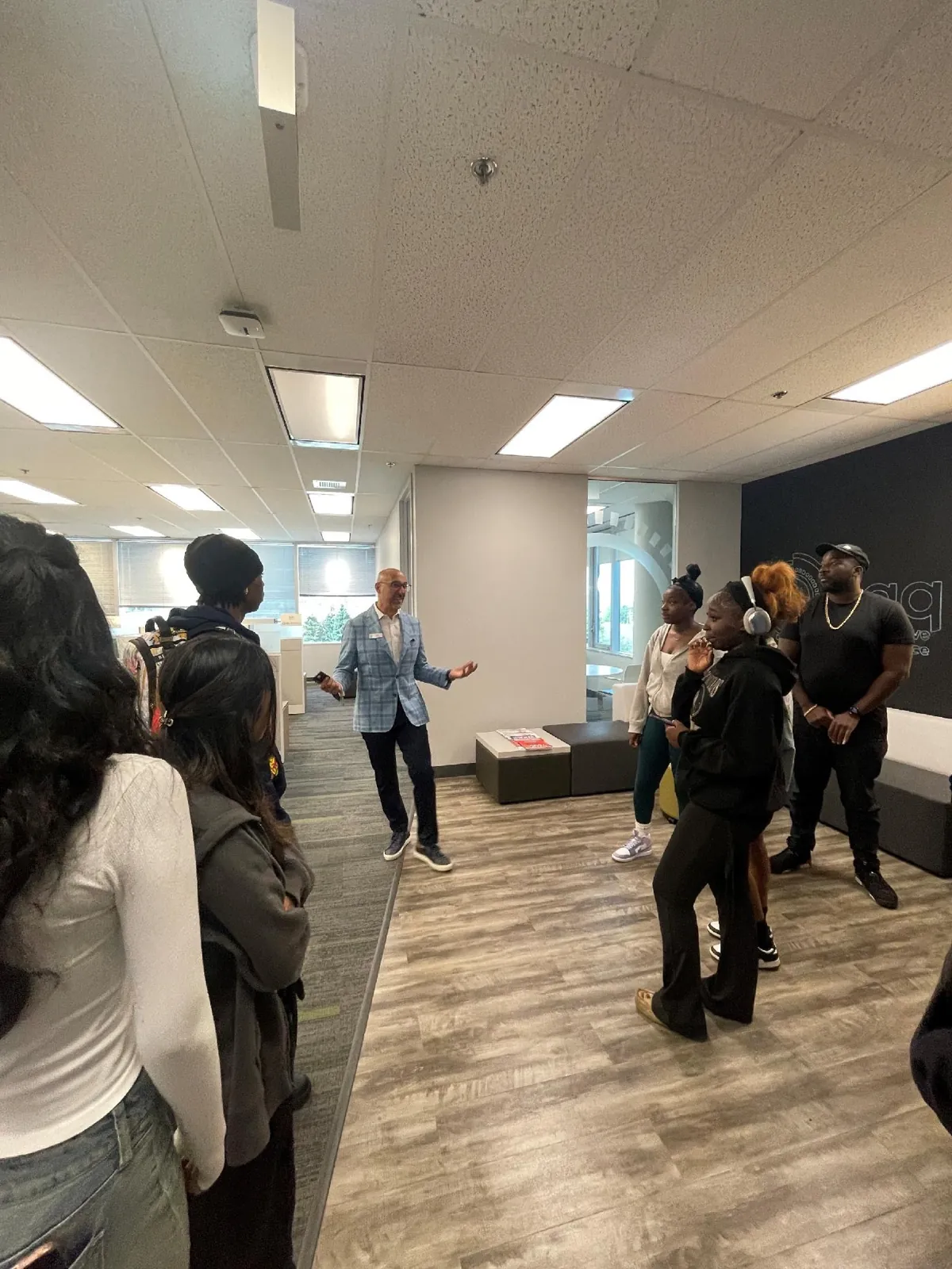 A host speaking with a group of students
